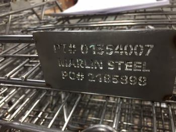 一个激光切割的钢板标签在一个定制的金属篮上。