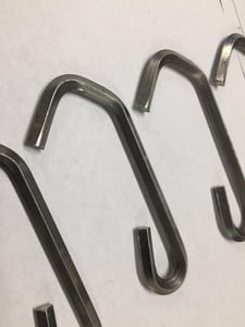 菱形金属丝钩比圆形金属丝更难成型，因为金属丝通过机器时的角度更重要。